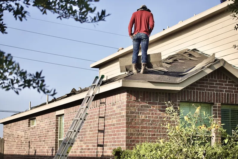 Professional roofer working on a residential roof in Orange Beach